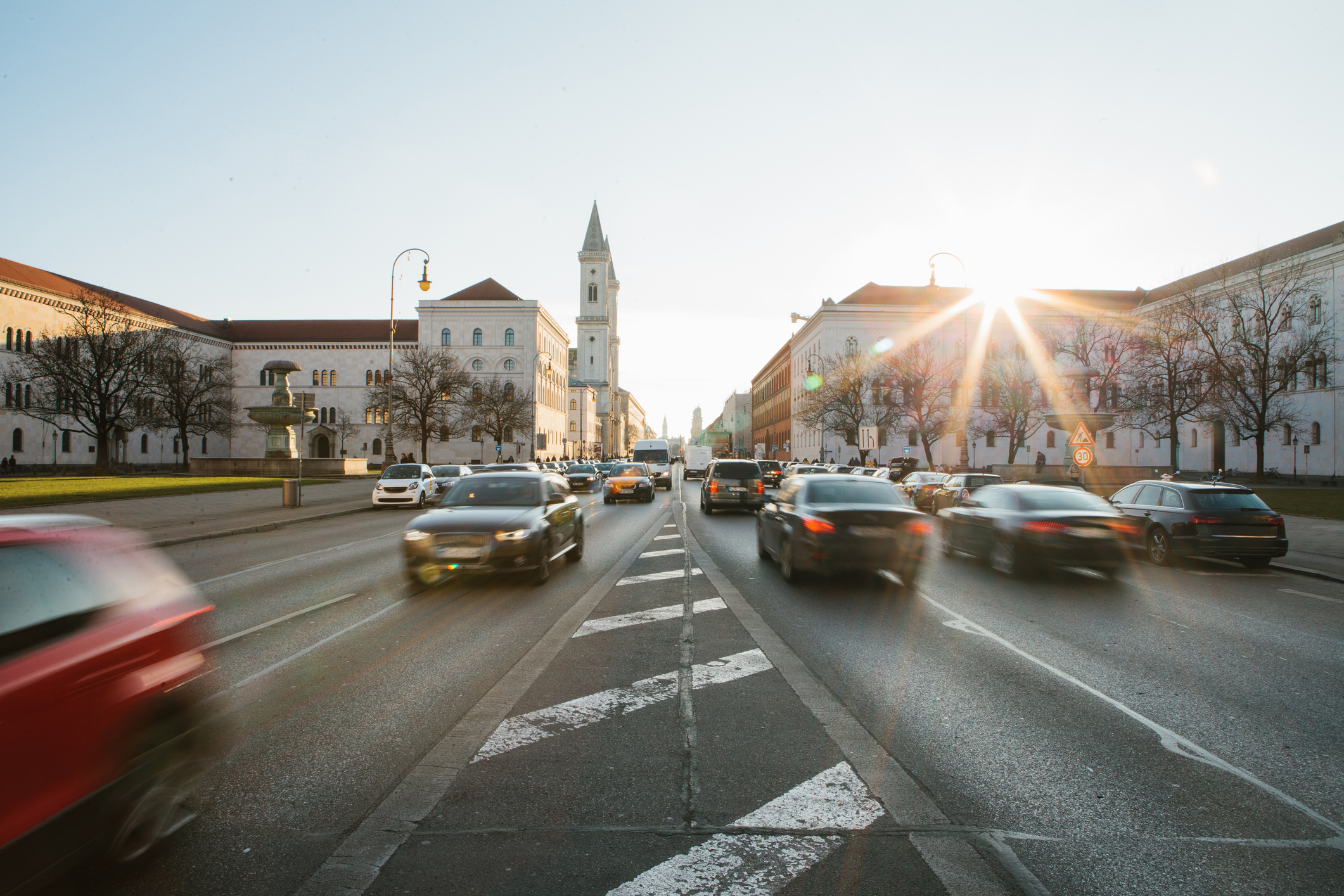 Leopoldstraße in München Blick auf die Straße auf der Leopoldstraße in München, Deutschland. Schnelle unscharfe Bewegung Auto auf Sonnenuntergang Hintergrund.